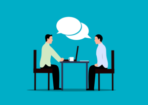 tekening van twee mensen die aan een tafel zitten en met elkaar praten