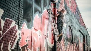 een muur met graffiti, met een graffitikunstenaar op een ladder