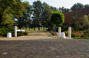 verschillende witte palen staan om de oprit van een boerderij