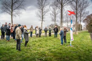 Een groepje mensen staat om een vliegtuigmarkering heen