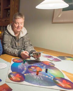 vrouw met spel voor zich op tafel