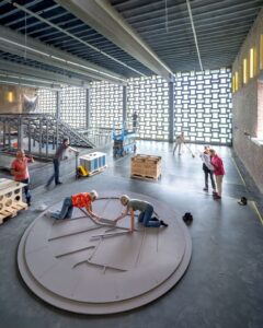 In een museumruimte zetten mensen een display in elkaar